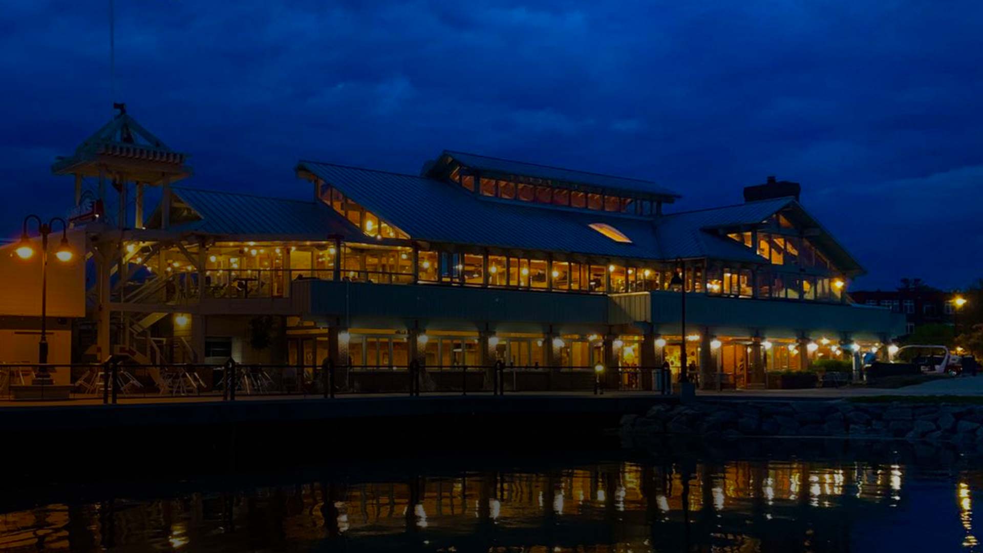 A waterfront restaurant in Door County glows warmly at night, its lights reflecting on calm water.