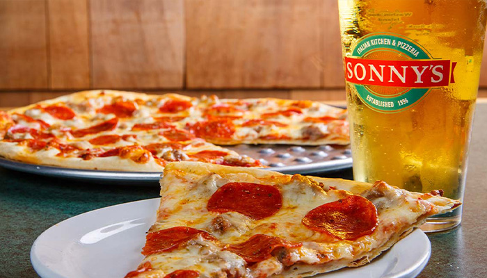 Pepperoni pizza slice on a plate at this Sturgeon Bay Waterfront Restaurant with Sonny’s beer.