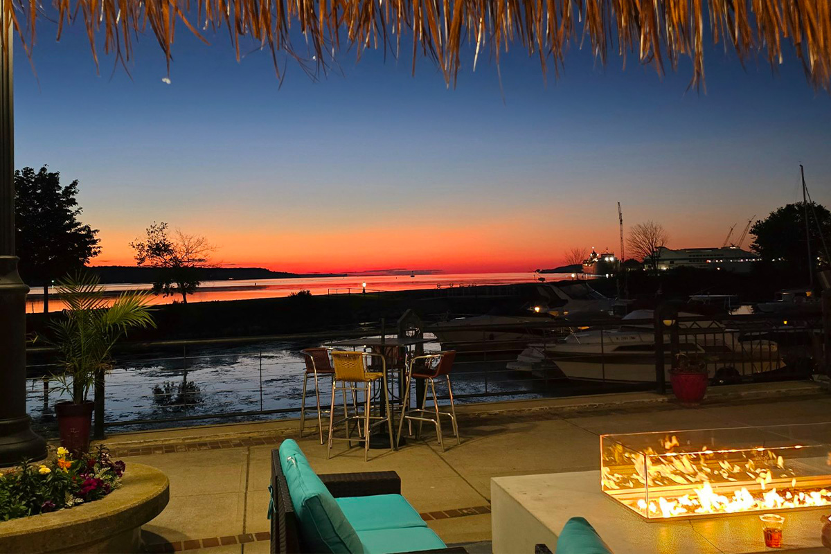 Sunset in Door County Wisconsin overlooking sturgeon Bay outside the Tiki Bar at Sonny's Italian Restaurant, the best waterfront views in Door County