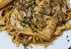 Fettuccine pasta with chicken and mushrooms in a brown sauce, served at our Sturgeon Bay location.