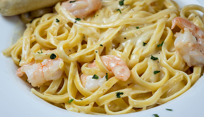 Fettuccine pasta with creamy sauce, shrimp, and parsley at our Door County waterfront restaurant.