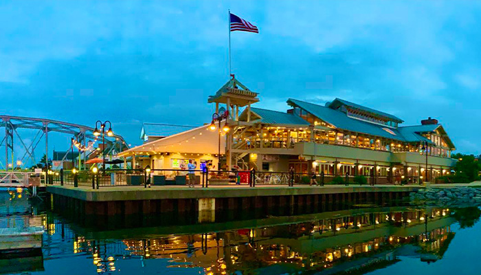 Sonny’s Italian Kitchen & Pizzeria glows at dusk in Sturgeon Bay, lights reflecting on the water.